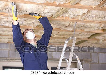 Man Wearing Protective Mask And Installing Ceiling