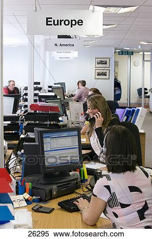 Sales People Working At Desks In Call Center Office Stock