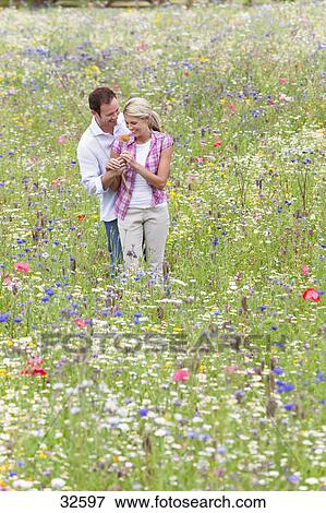 https://fscomps.fotosearch.com/compc/JCE/JCE011/man-giving-woman-flower-in-wildflower-stock-photo__32597.jpg