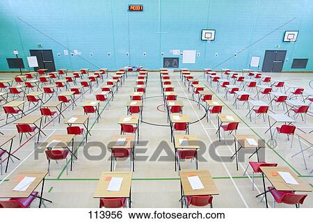 Rows Of Desks With Examinations Ready In School Gymnasium Stock