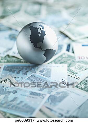 Picture - Metal globe resting on paper currency. Fotosearch - Search Stock Photography, Photos, Prints, Images, and Photo Clipart