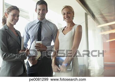 Stock Photograph - Business people standing together in office. Fotosearch - Search Stock Photography, Posters, Pictures, and Photo Clipart Images