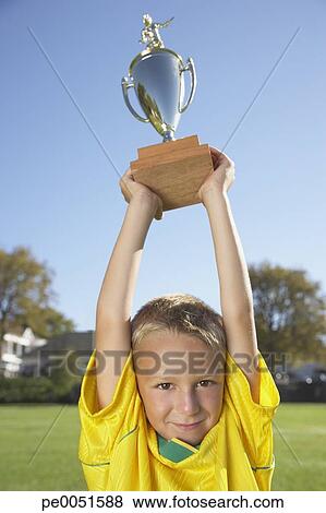 A boy holding up a trophy Stock Photo | pe0051588 | Fotosearch