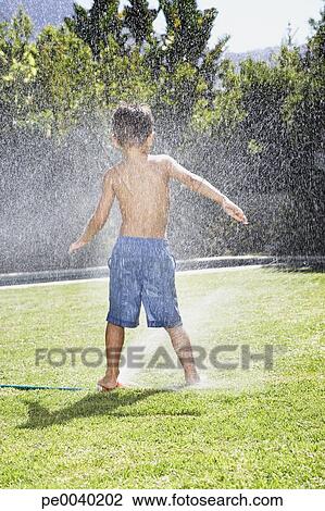 A young boy playing in a sprinkler Stock Image | pe0040202 | Fotosearch