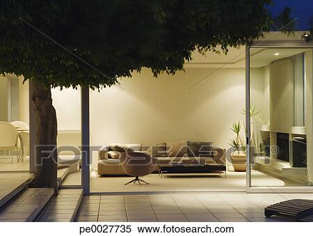 Stock Image - Modern living room and patio with sliding glass walls. Fotosearch - Search Stock Photos, Mural Pictures, Photographs, and Photo Clipart
