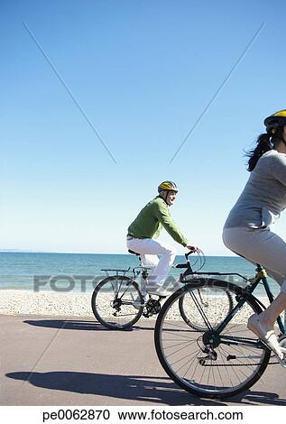 Couple Riding Bicycles On Beach Couple Riding Bicycles On Beach