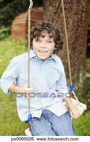 Boy Swinging In Backyard Stock Photograph Pe0065026 Fotosearch