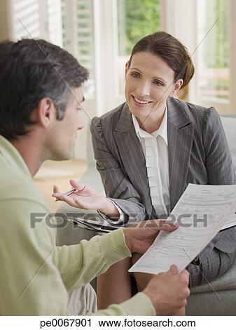 Stock Photography - Businesswoman discussing paperwork with man. Fotosearch - Search Stock Photos, Pictures, Prints, Images, and Photo Clip Art