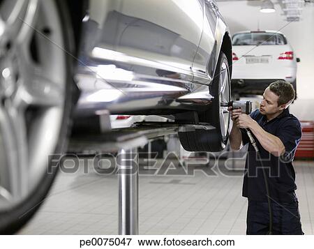 Mechanic working on car in auto repair shop Stock Photo - Mechanic Working On Car In Auto Repair Stock Photo  Pe0075047