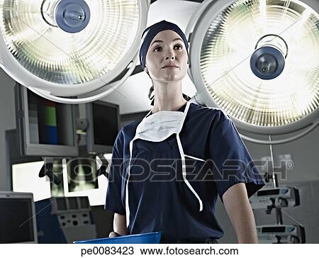 Stock Photo - Portrait of confident nurse under surgical lights. Fotosearch - Search Stock Images, Poster Photographs, Pictures, and Clip Art Photos