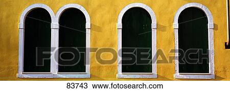 Stock Image - Windows in Yellow Wall Venice Italy. Fotosearch
