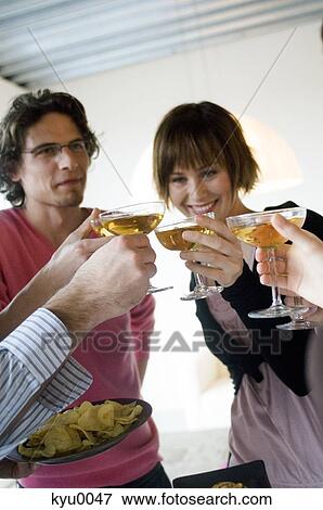 Stock Photo - 2 couples clinking glasses of champagne. Fotosearch