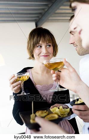 Stock Photo - 2 women and a man holding glasses of champagne. Fotosearch