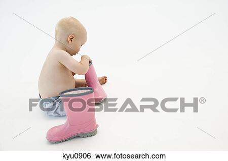 Baby boy playing with rubber boots View Large Photo Image Stock Photograph - Baby boy playing with rubber boots. Fotosearch