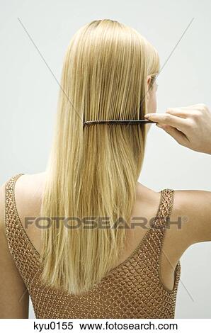 Stock Photography - Blond woman combing her hair. Fotosearch