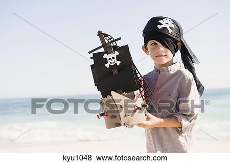 Boy in pirate costume playing with a toy boat View Large Photo Image Stock Photo - Boy in pirate costume playing with a toy boat. Fotosearch