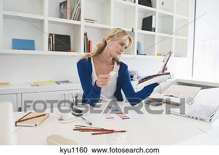 Stock Image - Businesswoman choosing color swatches. Fotosearch
