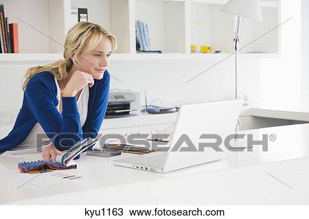 Stock Image - Businesswoman choosing color swatches. Fotosearch