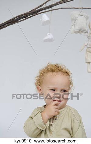 Close-up of a baby boy with toys hanging from sticks above him View Large Photo Image Stock Image - Close-up of a baby boy with toys hanging from sticks above him. Fotosearch