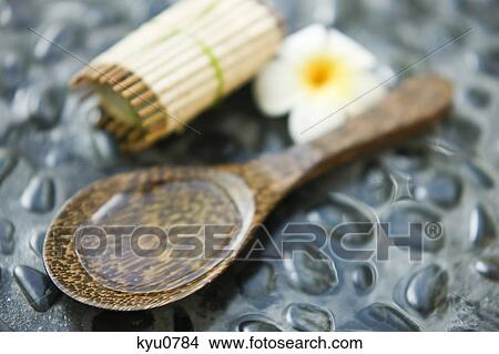 Picture - Close-up of a bar of soap with a flower and aromatherapy oil in a spoon. Fotosearch