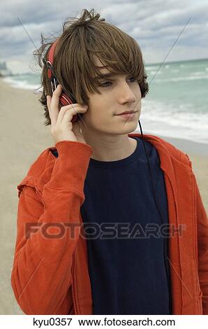 Close-up of a boy listening to headphones View Large Photo Image Stock Photo - Close-up of a boy listening to headphones. Fotosearch
