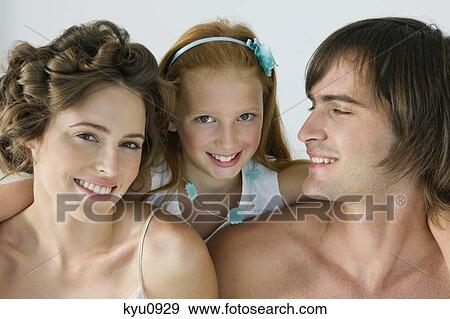 Stock Photo - Close-up of a couple smiling with their daughter. Fotosearch
