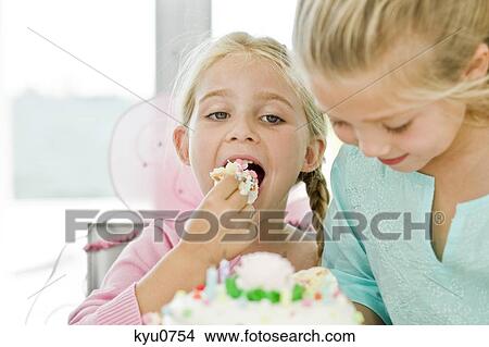 Picture - Close-up of a girl eating birthday cake. Fotosearch