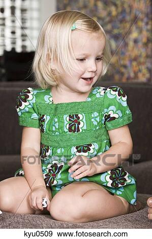 Close-up of a girl holding a dice and smiling View Large Photo Image Stock Photo - Close-up of a girl holding a dice and smiling. Fotosearch
