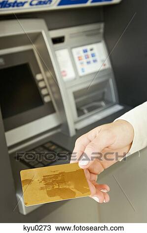 Stock Image - Close-up of a person's hand holding a credit card. Fotosearch