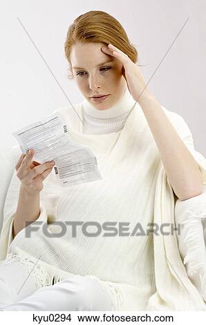 Picture - Close-up of a pregnant young woman reading a medical report. Fotosearch