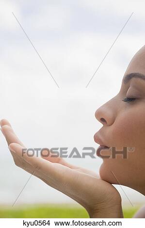 Picture - Close-up of a woman blowing a kiss. Fotosearch