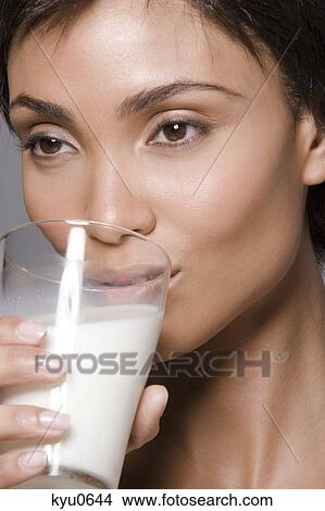Close-up of a woman drinking milk from a glass View Large Photo Image Picture - Close-up of a woman drinking milk from a glass. Fotosearch