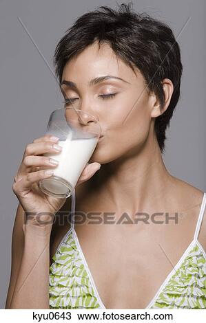 Stock Image - Close-up of a woman drinking milk from a glass. Fotosearch