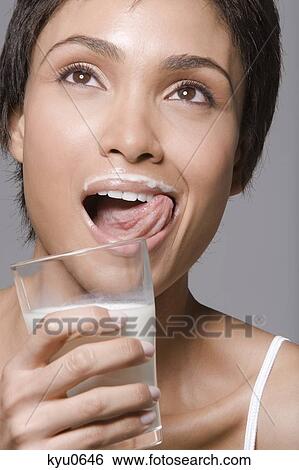 Close-up of a woman drinking milk from a glass View Large Photo Image Stock Photograph - Close-up of a woman drinking milk from a glass. Fotosearch
