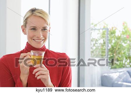 Stock Photo - Close-up of a woman holding a cup of tea. Fotosearch