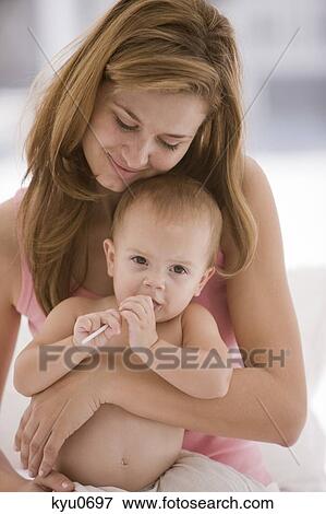 Close-up of a woman holding her daughter View Large Photo Image Stock Photo - Close-up of a woman holding her daughter. Fotosearch