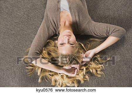 Stock Photograph - Close-up of a woman lying on a round sofa. Fotosearch