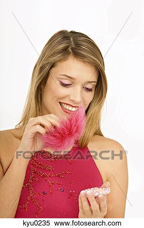 Close-up of a young woman applying make-up View Large Photo Image Stock Photography - Close-up of a young woman applying make-up. Fotosearch