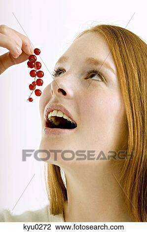 Close-up of a young woman eating red currants View Large Photo Image Stock Image - Close-up of a young woman eating red currants. Fotosearch