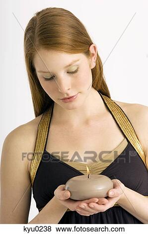 Close-up of a young woman holding a burning candle View Large Photo Image Stock Photo - Close-up of a young woman holding a burning candle. Fotosearch