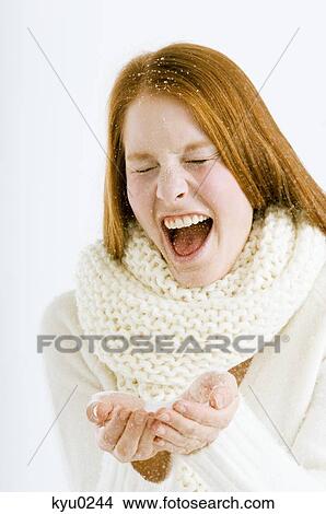 Picture - Close-up of a young woman playing with snow. Fotosearch