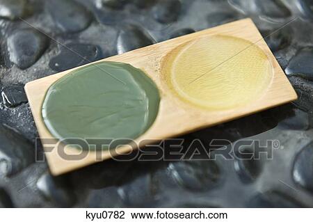 Stock Image - Close-up of aromatherapy oil and mud pack in a tray. Fotosearch