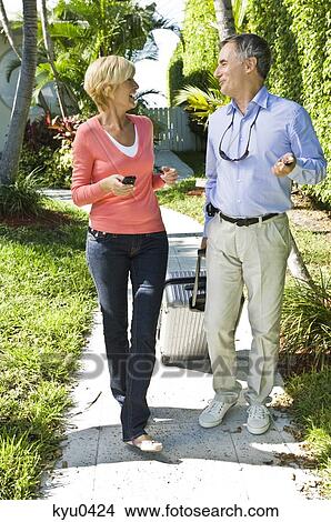 Picture - Couple looking at each other and walking. Fotosearch