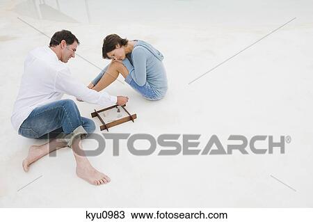 Stock Image - Couple playing with a sandbox. Fotosearch