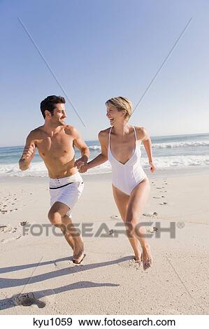 Stock Photo - Couple running on the beach. Fotosearch