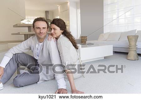Stock Image - Couple sitting on the floor. Fotosearch