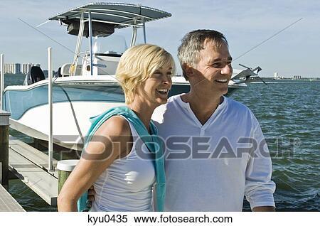 Stock Photography - Couple standing on a pier and smiling. Fotosearch