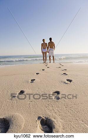 Couple standing on the beach View Large Photo Image Stock Image - Couple standing on the beach. Fotosearch