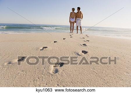 Couple standing on the beach View Large Photo Image Stock Image - Couple standing on the beach. Fotosearch