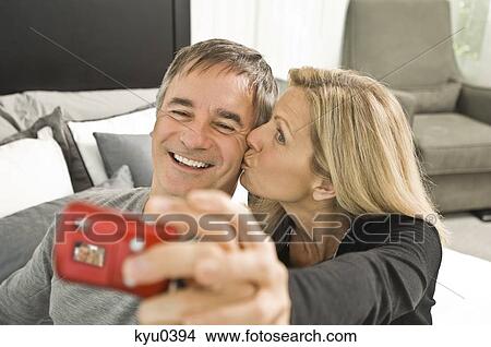 Couple taking picture of themselves with a digital camera View Large Photo Image Picture - Couple taking picture of themselves with a digital camera. Fotosearch